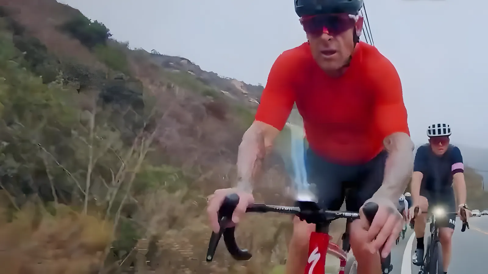 Bus Stop rider in a red jersey leading the group up a hillside road