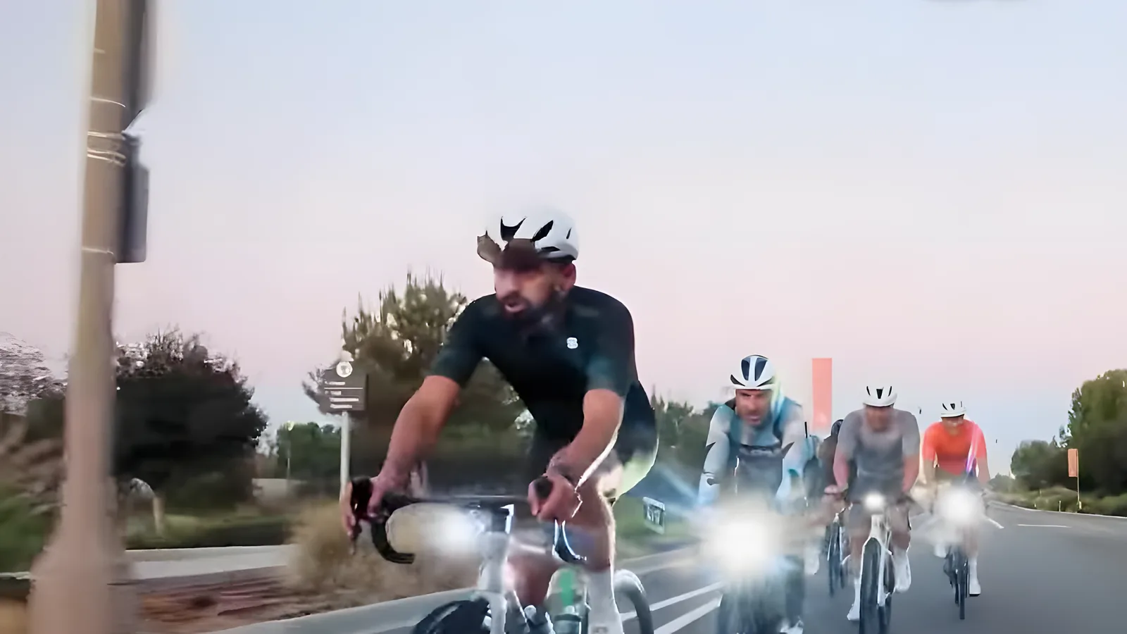 Coffee Crew pack with headlights on a wide road at first light