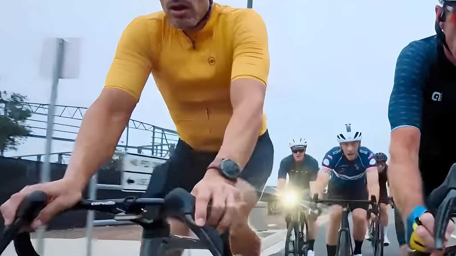 Coffee Crew riders on an early-morning ride, led by a rider in a yellow jersey